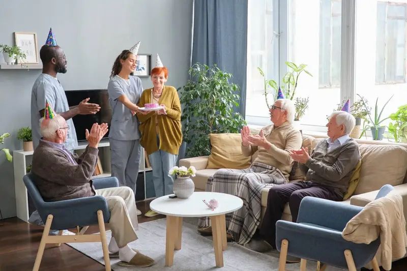Carers sharing a celebration with elderly clients at home