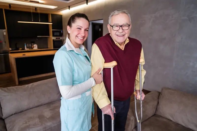 Carer and elderly client smiling together at home
